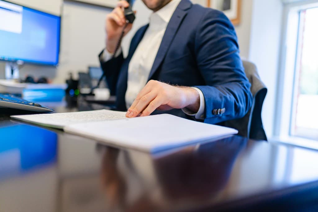 Professional on a discovery call with notes at a desk