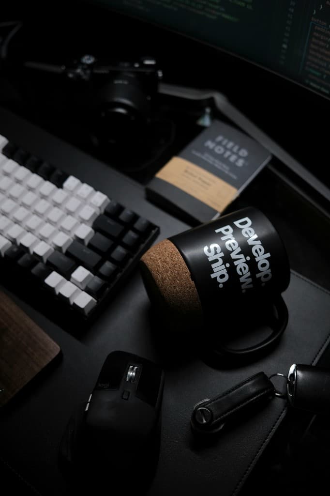 Desk setup with a mug that reads Develop, Preview, Ship